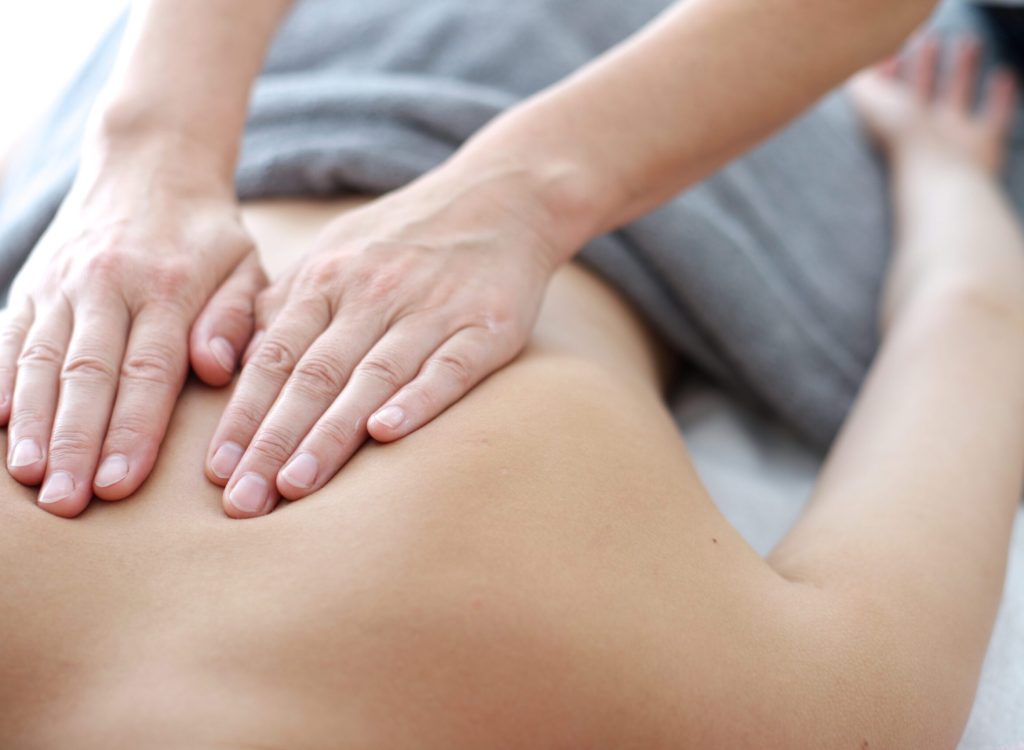 Close up of back massage procedure in spa salon