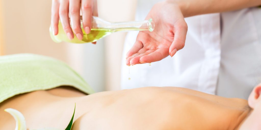 Beautiful woman having a wellness back massage and feeling visibly good about it
